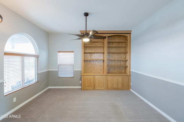 unfurnished room featuring ceiling fan, light carpet, and baseboards