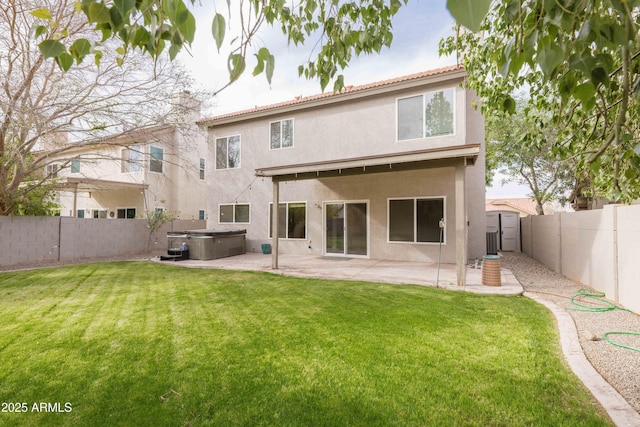 back of property featuring a patio, stucco siding, a lawn, a hot tub, and a fenced backyard