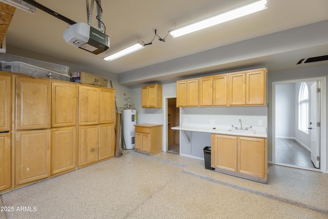 kitchen with light brown cabinets, electric water heater, a sink, baseboards, and light countertops