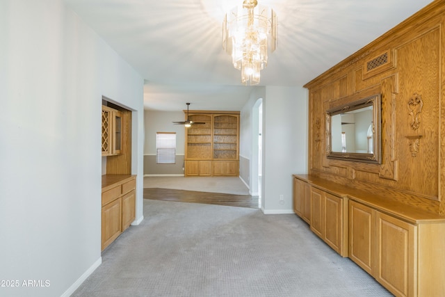 interior space with arched walkways, a notable chandelier, visible vents, light carpet, and baseboards