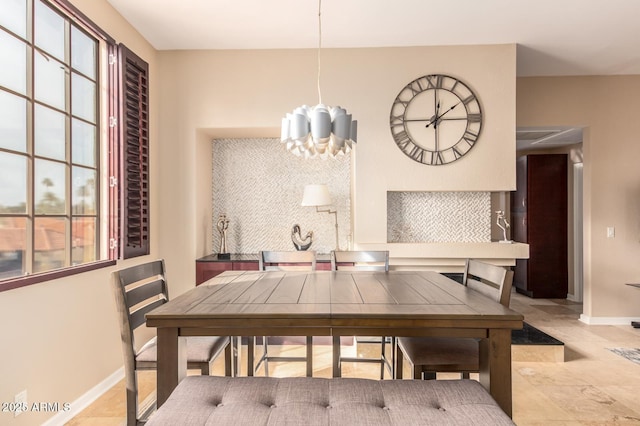 dining space featuring a chandelier and baseboards