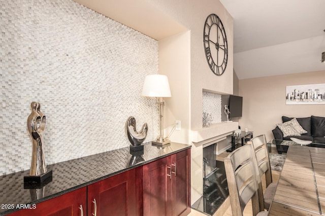 interior space with dark countertops, vaulted ceiling, and dark brown cabinets