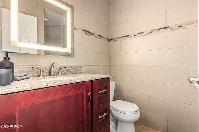 half bathroom with toilet, tile walls, and vanity