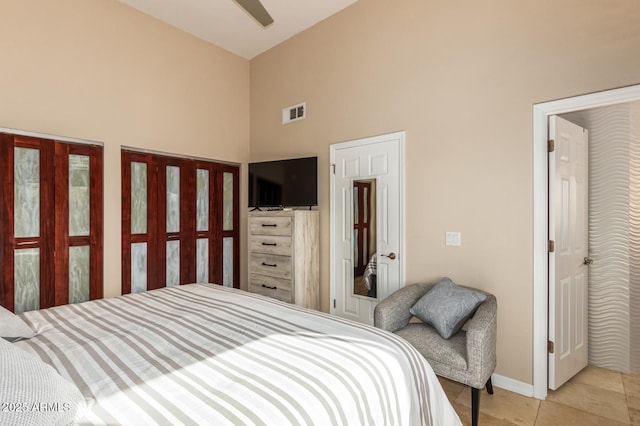 bedroom featuring baseboards, visible vents, a ceiling fan, high vaulted ceiling, and light tile patterned flooring