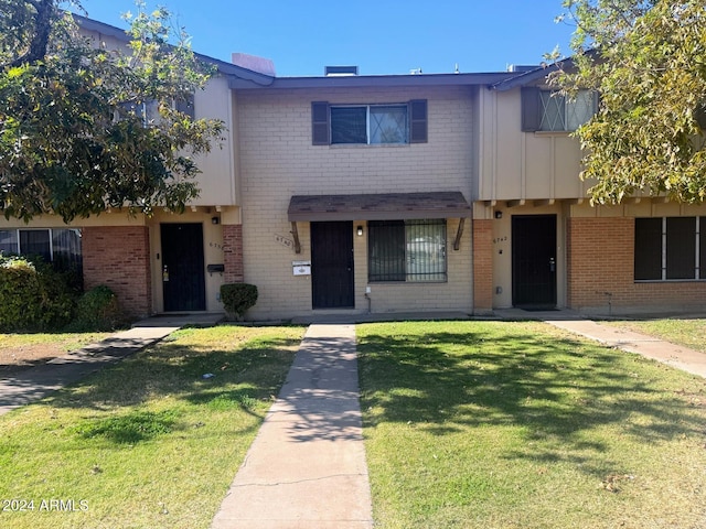 townhome / multi-family property featuring a front lawn