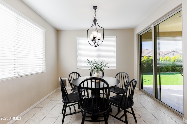 tiled dining room with an inviting chandelier