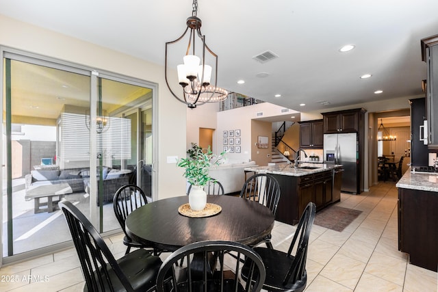 tiled dining area with sink and a chandelier