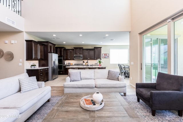 living room featuring light hardwood / wood-style floors and a high ceiling