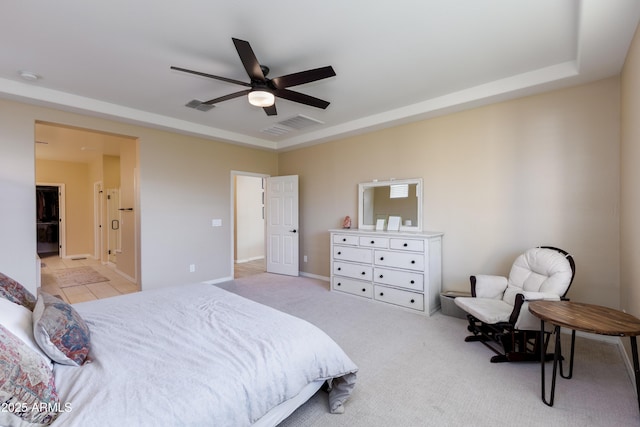 bedroom with a raised ceiling, light carpet, and ceiling fan