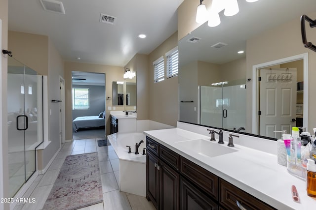 bathroom featuring plus walk in shower, vanity, and tile patterned floors