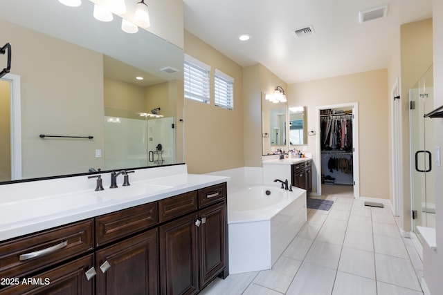 bathroom featuring plus walk in shower, vanity, and tile patterned floors