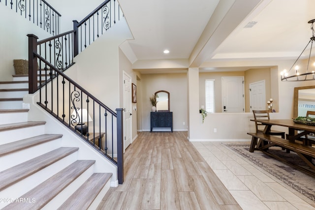 foyer entrance with a notable chandelier and light hardwood / wood-style flooring