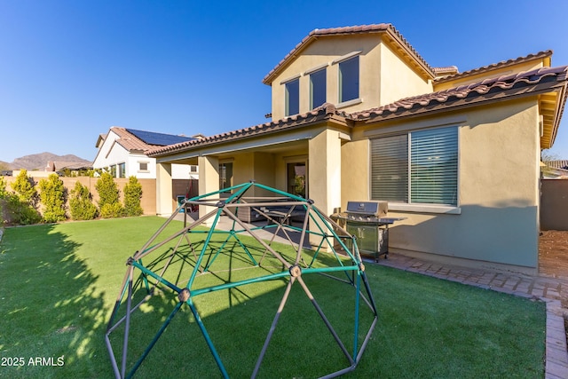 back of property with a yard and a mountain view