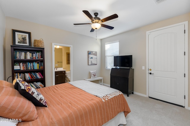 bedroom with ceiling fan, light carpet, and ensuite bathroom