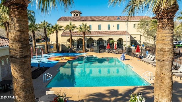 view of pool featuring a jacuzzi and a patio