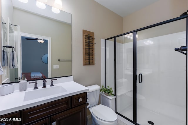 bathroom with vanity, a shower with door, and toilet