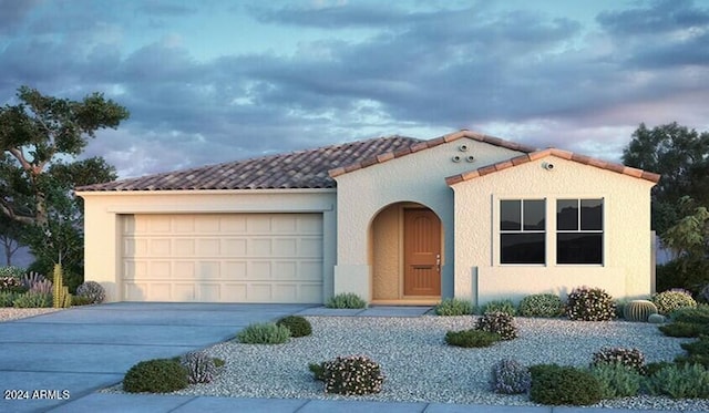 mediterranean / spanish house featuring a garage, concrete driveway, a tiled roof, and stucco siding