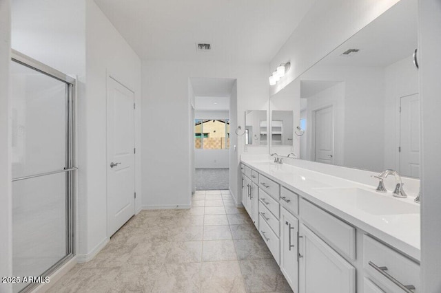 full bath featuring a shower with door, a sink, visible vents, and double vanity