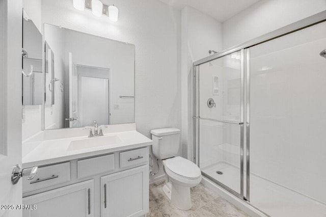 bathroom with a stall shower, vanity, and toilet