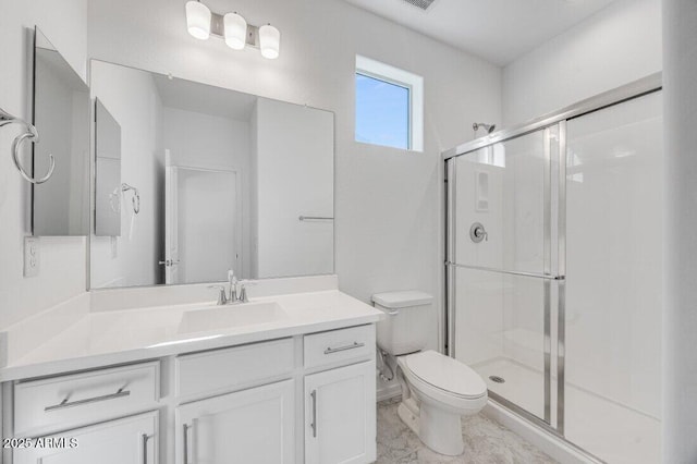 full bath with a stall shower, vanity, and toilet