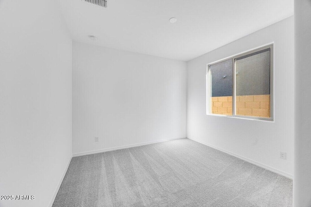 spare room featuring visible vents, baseboards, and carpet flooring