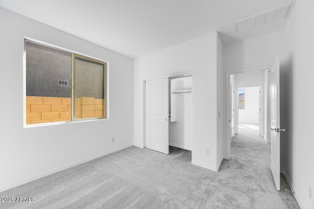 unfurnished bedroom featuring a closet, carpet flooring, visible vents, and baseboards