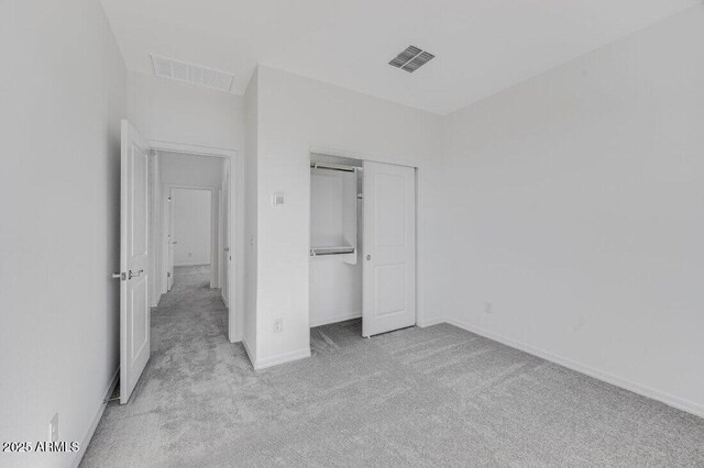 unfurnished bedroom featuring carpet flooring, visible vents, and baseboards