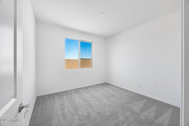 carpeted empty room with baseboards