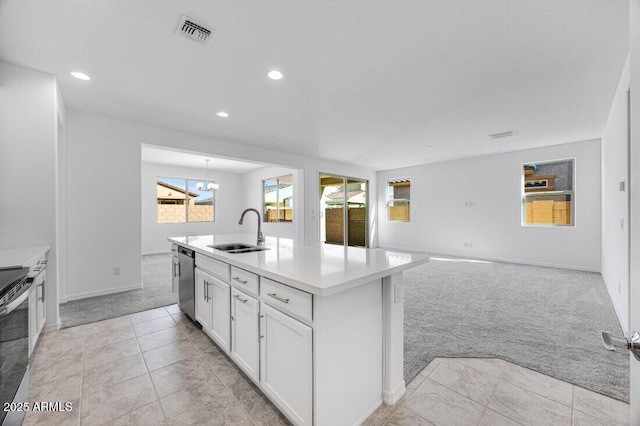 kitchen with light carpet, a sink, visible vents, white cabinetry, and appliances with stainless steel finishes