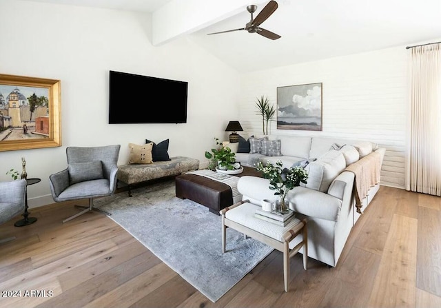 living room featuring ceiling fan, lofted ceiling with beams, and light wood-type flooring