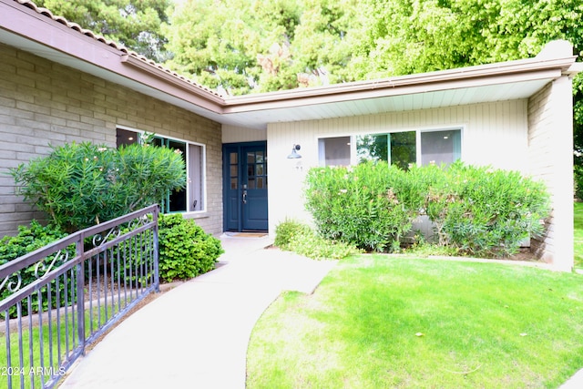 doorway to property featuring a lawn