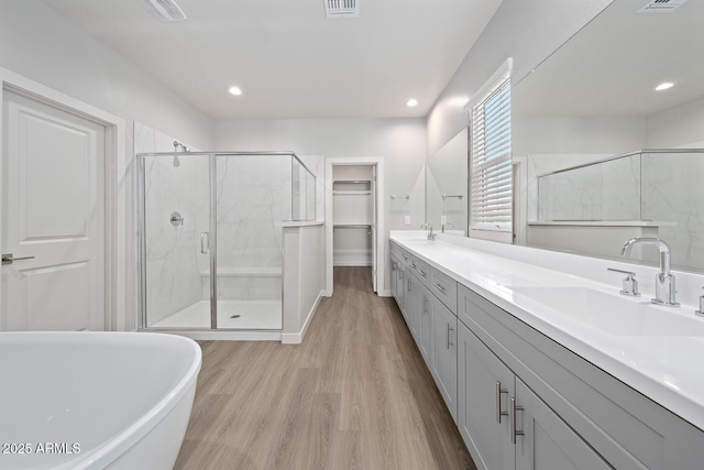 651 W Laredo St, Chandler, AZ 85225 - bathroom featuring double vanity, a stall shower, wood finished floors, a soaking tub, and a walk in closet