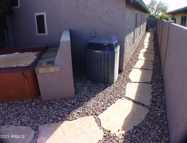 4506 E Lone Cactus Dr, Phoenix, AZ 85050 - view of side of home featuring stucco siding, a hot tub, central AC, and fence