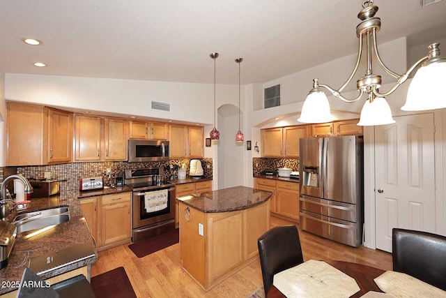 4506 E Lone Cactus Dr, Phoenix, AZ 85050 - kitchen with stainless steel appliances, a sink, a center island, tasteful backsplash, and lofted ceiling
