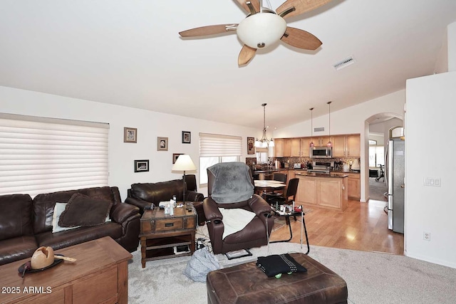 4506 E Lone Cactus Dr, Phoenix, AZ 85050 - living room featuring arched walkways, ceiling fan, lofted ceiling, light colored carpet, and a chandelier