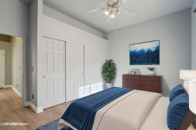 bedroom with ceiling fan, light hardwood / wood-style flooring, and a closet