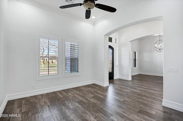 unfurnished room featuring baseboards, arched walkways, dark wood finished floors, and crown molding