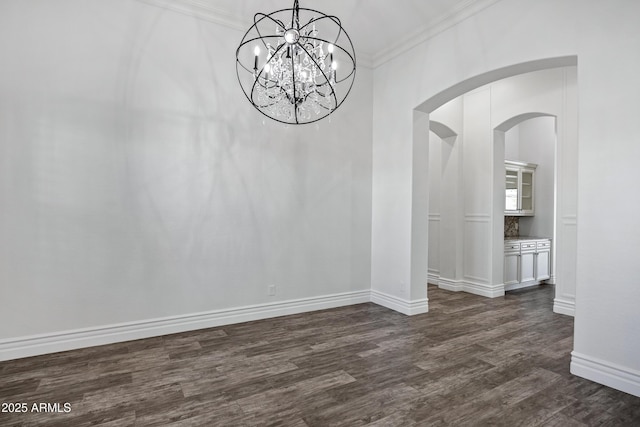 unfurnished dining area featuring dark wood-style floors, ornamental molding, arched walkways, and baseboards