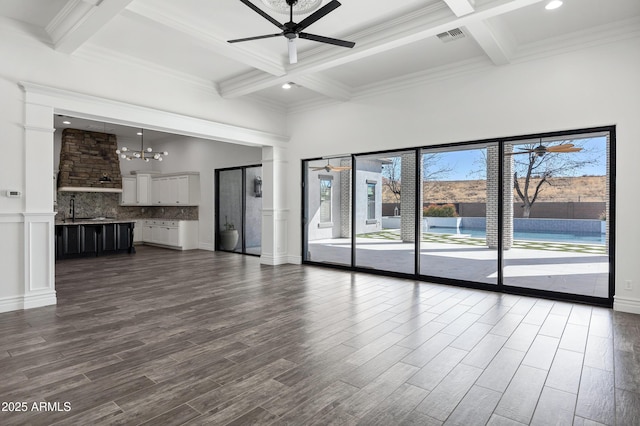 unfurnished living room with dark wood-style floors, a wealth of natural light, visible vents, and a high ceiling