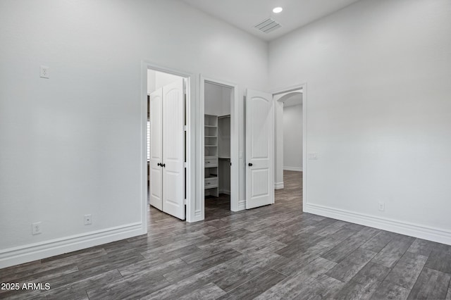 spare room with dark wood-style floors, baseboards, visible vents, and recessed lighting