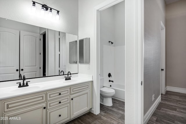 full bath featuring  shower combination, a sink, and wood finished floors