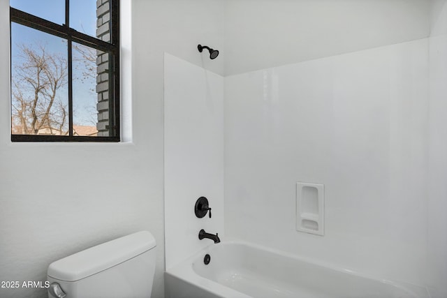 full bath with shower / bath combination, toilet, and a wealth of natural light