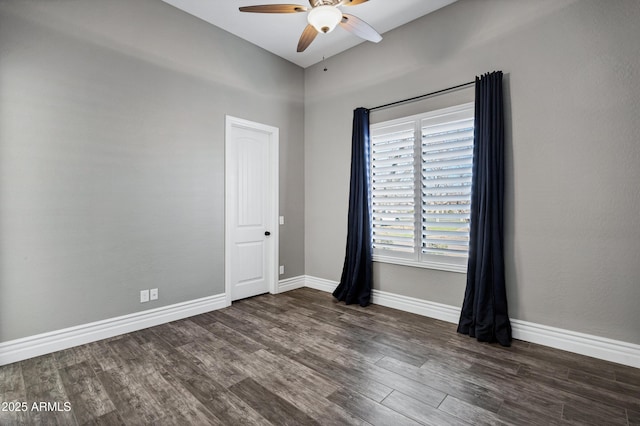 empty room featuring dark wood-style floors, baseboards, and a ceiling fan