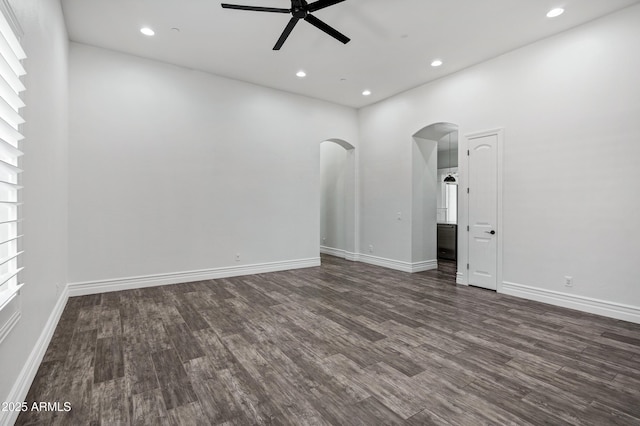 unfurnished room featuring ceiling fan, arched walkways, dark wood-style flooring, and recessed lighting