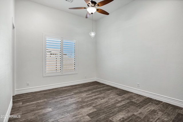 unfurnished room featuring dark wood-style flooring, visible vents, and baseboards