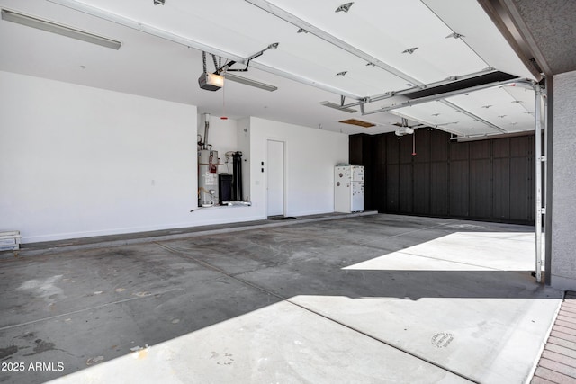 garage with water heater, a garage door opener, and baseboards