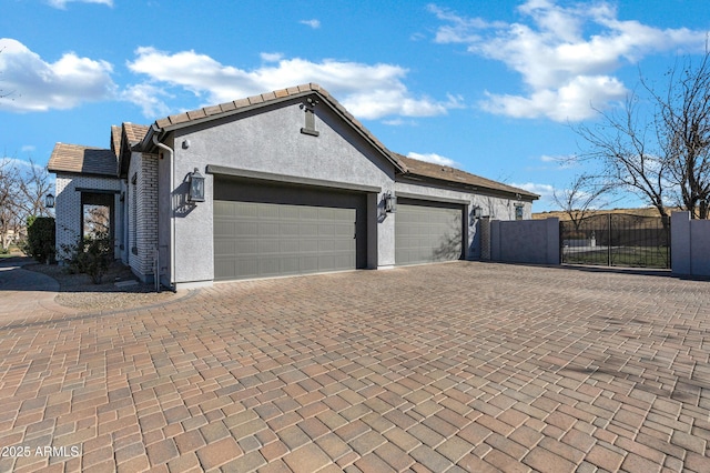 exterior space with decorative driveway and a gate