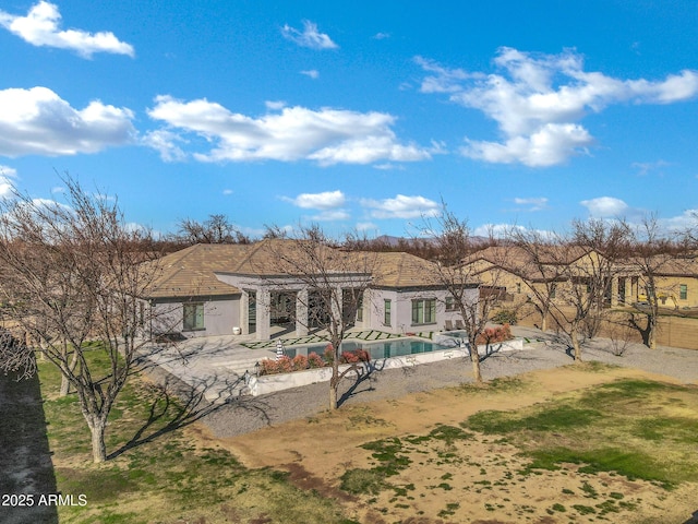 rear view of house with a patio area, an outdoor pool, and fence