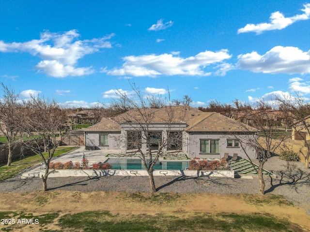 back of house featuring an outdoor pool, a patio, and stucco siding