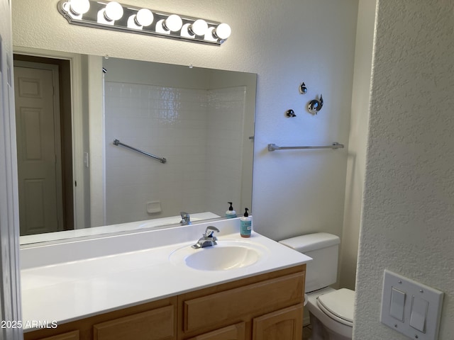 bathroom with a shower, vanity, and toilet